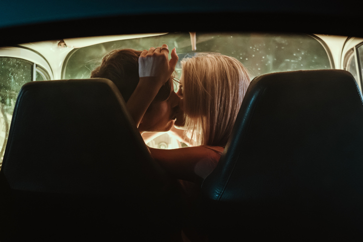 Young couple kissing each other in car during date