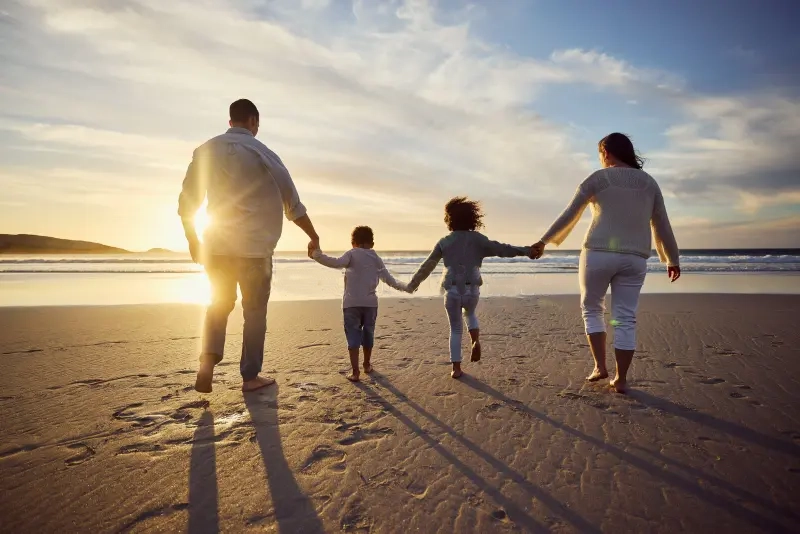 rear-view-shot-carefree-family-holding-hands-walking-sunset-mixed-race-parents-their-two-kids-spending-252038109